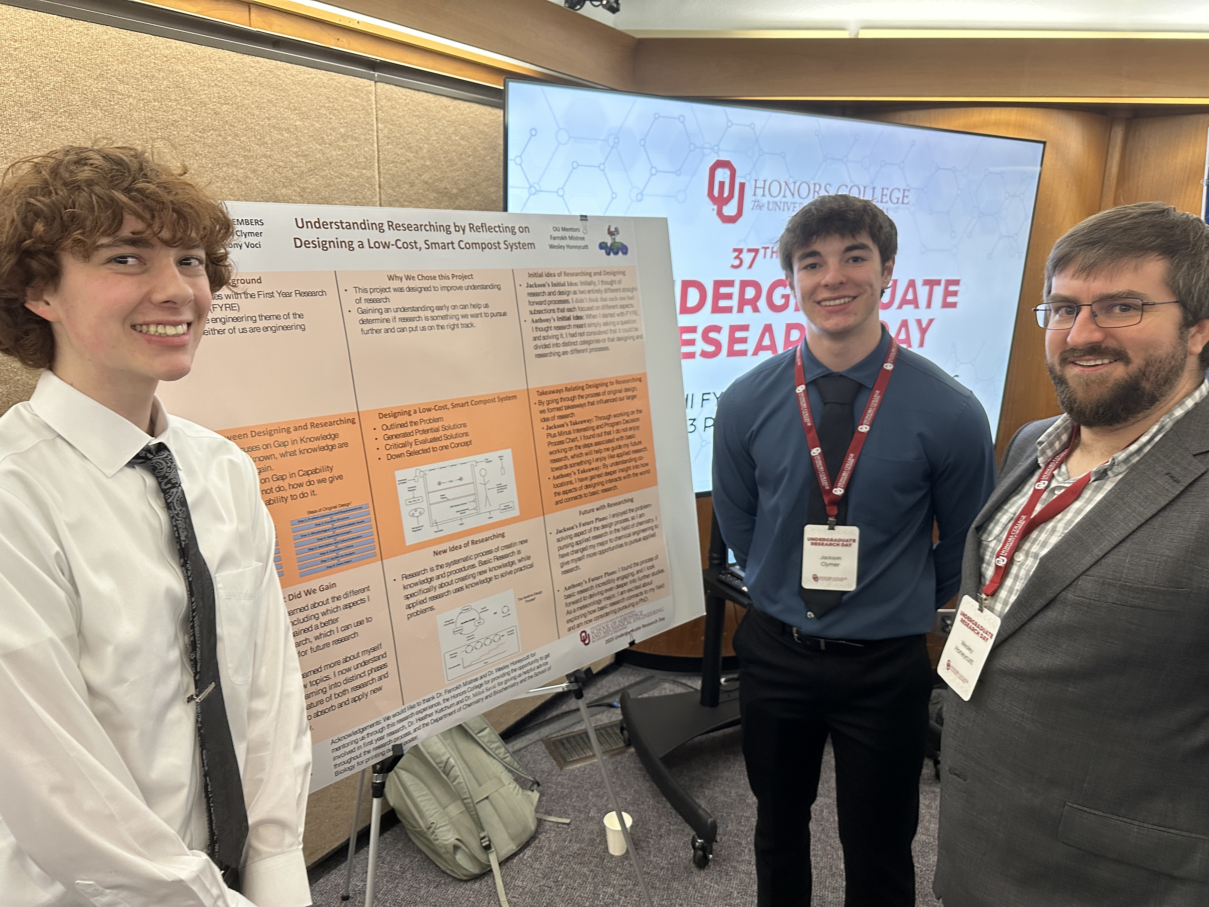 Anthony Voci, Jackson Clymer, and Wes stand stand around their poster.